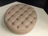 a round ottoman sitting on the floor in a room