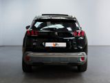 the rear end of a black suv parked in a white room