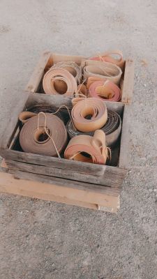 de nombreux rouleaux de ruban adhésif dans une caisse en bois posée par terre