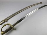 a close up of two swords on a white surface