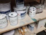 many cans of paint sitting on a shelf in a room