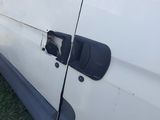 a white van that has been vandalized and is parked in the grass