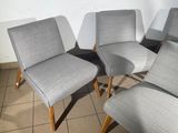 four grey chairs are lined up against a wall in a room