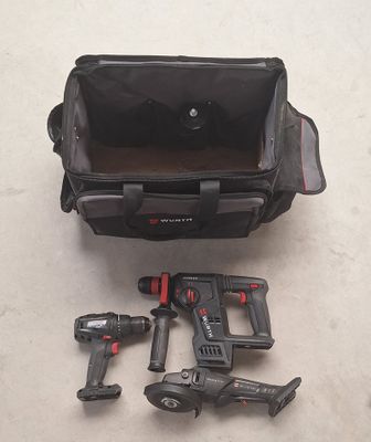 un sac noir contenant des outils, posé par terre