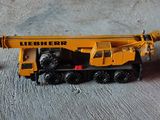 un camion miniature équipé d'une grue, à côté d'une canette de soda