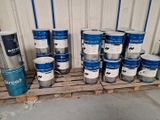 de nombreux pots de peinture posés sur une palette dans un entrepôt