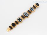 a black and gold bracelet with black and white beads