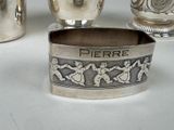 a silver container with a design on it next to other silver objects