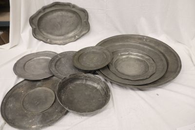 un grand nombre d'assiettes en argent posées sur une nappe blanche