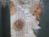 a piece of paper on the side of a rusted metal container