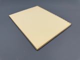 un cahier blanc posé sur une table, sur fond noir