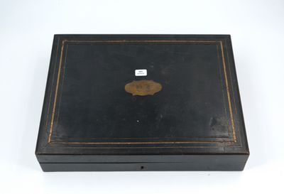 an old black box with a gold medallion on the lid