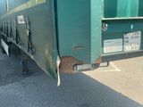 a green truck that is parked on the side of the road