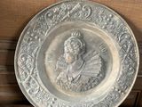 a silver plate with a picture of a woman on it
