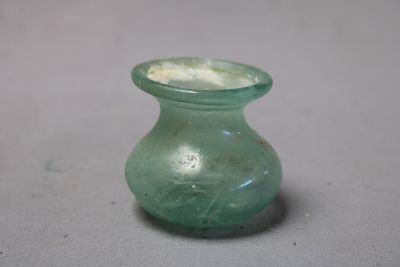 un vase en verre vert percé d'un petit trou