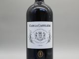 une bouteille de vin rouge posée sur une table blanche