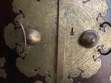 a close up of a large metal door with gold decorations on it