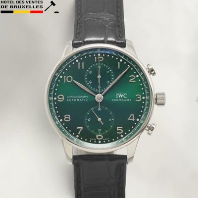 a close up of a wrist watch with a green dial