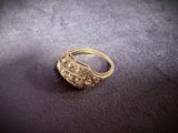 a close up of a gold ring with diamonds on a purple surface