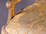 gold and white upholstered upholstered chair against a gray background