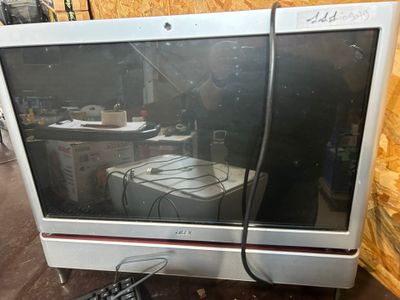 a computer monitor sitting on a table with a keyboard