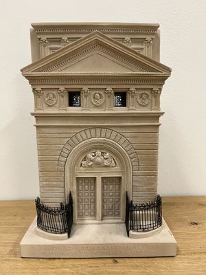 a small model of a building on a wooden table