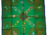 a green and blue square scarf with a cross on it