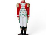 petit soldat en bois vêtu d'un uniforme rouge et vert, sur fond blanc