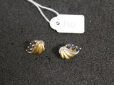 two pairs of earrings are on a black surface next to a price tag