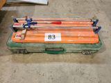 une valise orange munie d'une poignée bleue et d'une poignée rouge