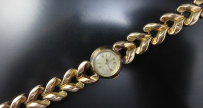 an image of a close up of a wrist watch on a mannequin