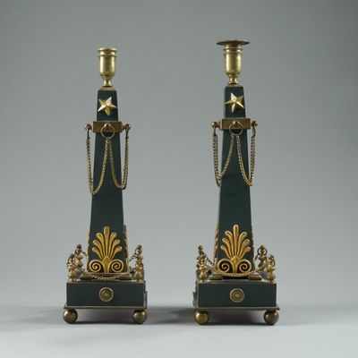 pair of black and gold candlesticks with chains on them
