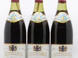 trois bouteilles de vin posées les unes à côté des autres sur une surface blanche