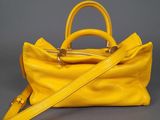 yellow leather handbag on grey background with strap
