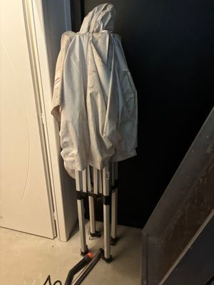 un manteau blanc accroché au mur à côté d'une paire de skis