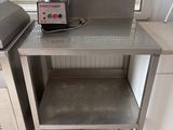 une petite table sur laquelle se trouve un mixeur, dans une cuisine