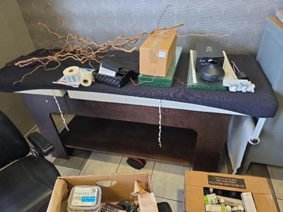Des cartons contenant des objets divers sont posés sur une table dans une pièce.