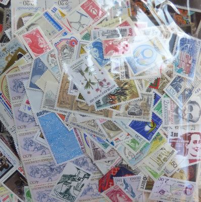 de nombreux timbres de toutes sortes dans un vase en verre posé sur la table