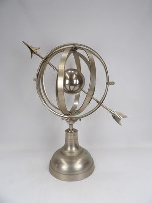 an image of a metal sculpture of a globe with arrows