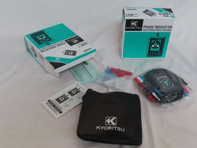 une boîte contenant une télécommande et d'autres objets, posée sur un lit