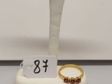 deux bagues en or et une bague en or posée sur un socle blanc