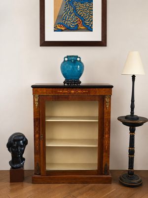 un vase bleu posé sur une table, à côté d'une lampe