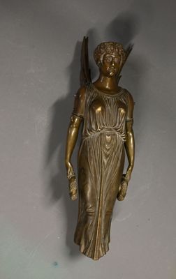 bronze statue of a woman holding a bird on a wall