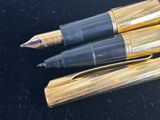 three pens that are sitting on top of a black box