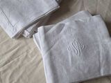 three folded towels with a monogram on them on a bed