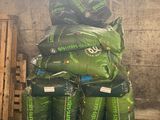 une pile de sacs remplis de matière verte posée sur une palette