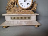 a gold clock sitting on top of a marble table