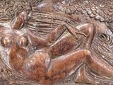 carvings of a woman and a bird in a field of grass