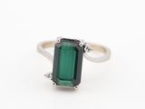 un gros plan d'une bague en tourmaline verte sur fond blanc
