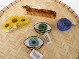 three hair clips and a comb sitting on a tray